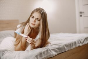 Elinde gebelik testi tutan kadın